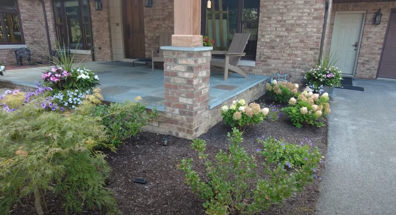 Professional landscaping with brick patio and lush garden beds in San Leandro, CA